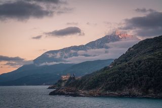 Гора Афон на закате. На переднем плане один из двадцати монастырей - греческий монастырь Ставроникита