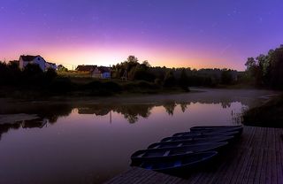 Спящие лодочки и отражения звезд на глади ночной реки. Зарево - какой - то город (наверное, Сергиев Посад).