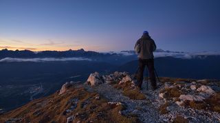 Мой напарник фотограф Денис Сорокин готовится завпечатлеть пробуждение облаков, встающих со своих постелей в ложбинах массива Юлианских Альп.