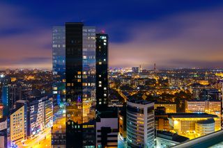 Aerial cityscape of modern business financial district with tall skyscraper buildings illuminated at night, Tallinn, Estonia