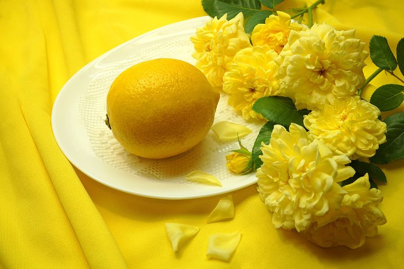 Спелый лимон и жёлтые розы.