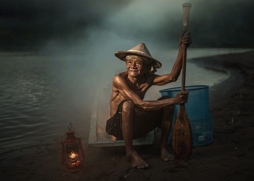 fisherman sitting near a river.