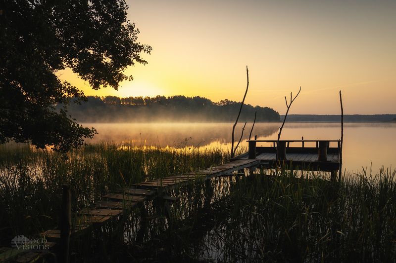 Sunrise by the foggy lake