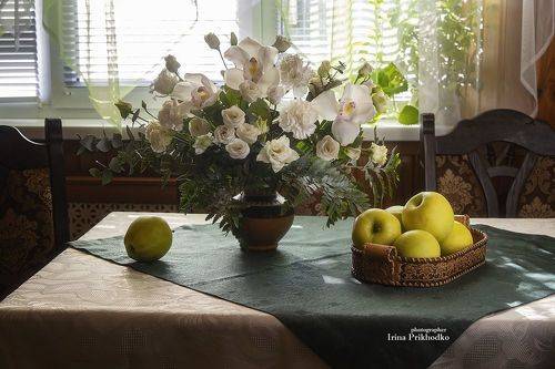 Цветы и яблоки на столе