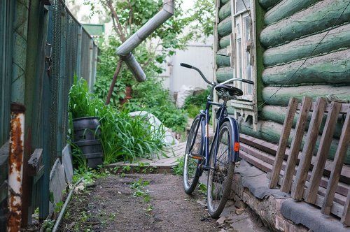 Старый велосипед у дома в деревне