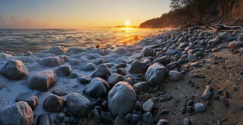 Каменистый берег и восходящее солнце