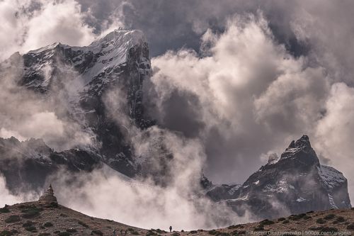 Cloudy Himalayas. Cholatse peak and silhouette of man